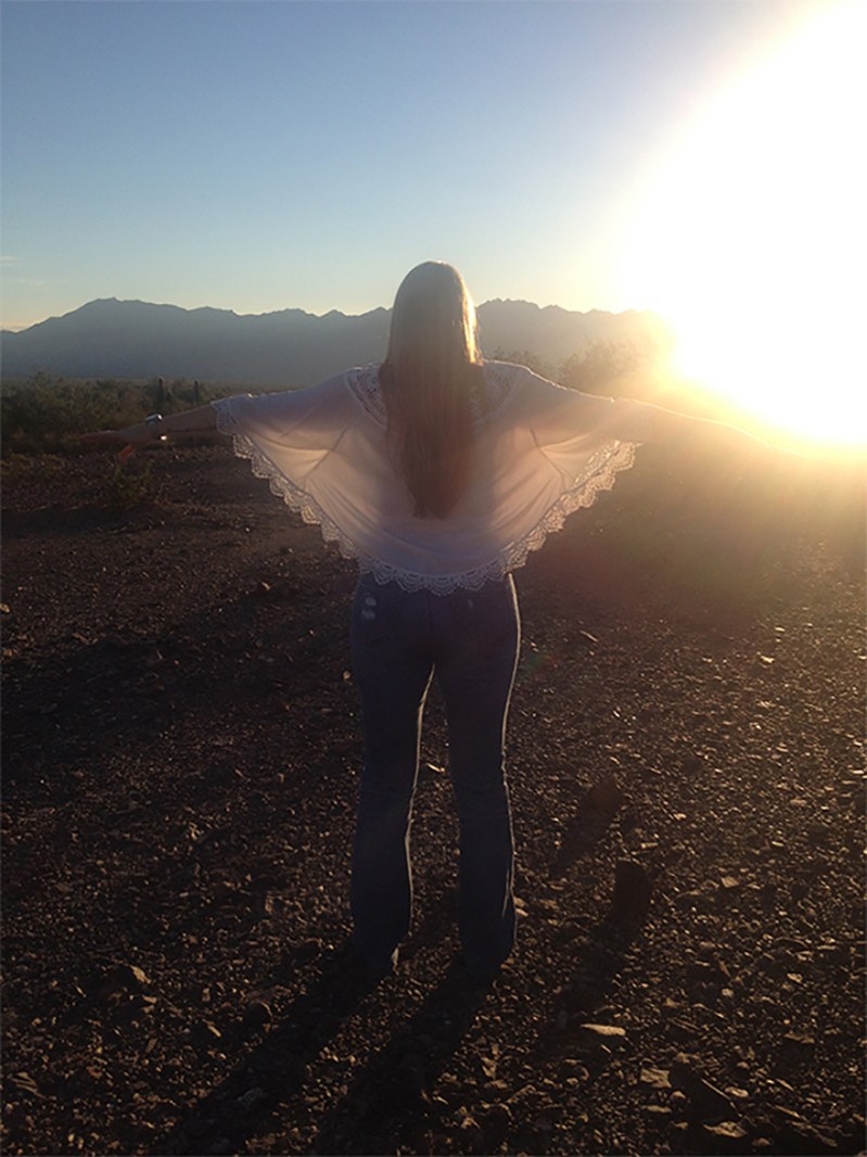 a tall woman embracing the sun light