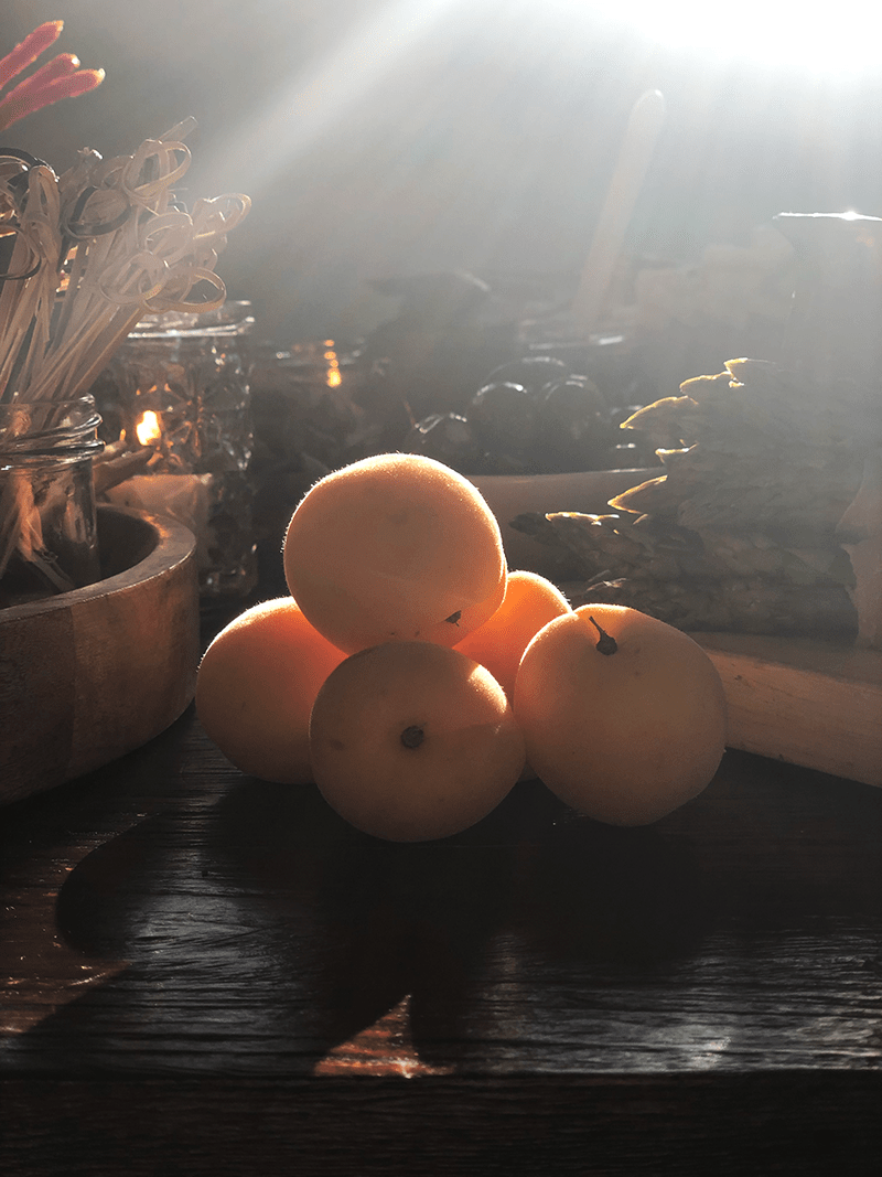 fresh apricots on a charcuterie table with sunlight shining in the back