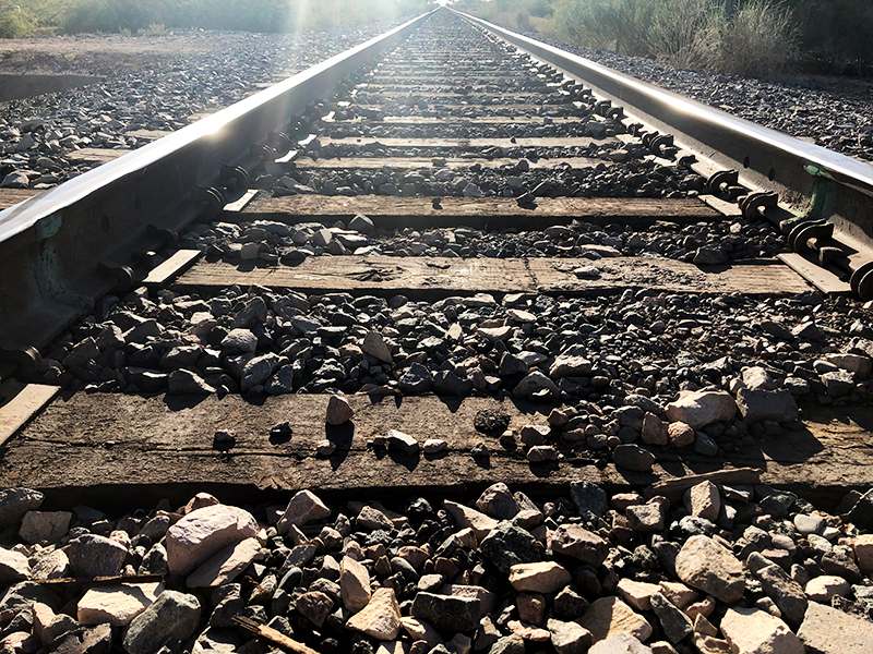 railroad tracks with the reflection of the sun on the tracks